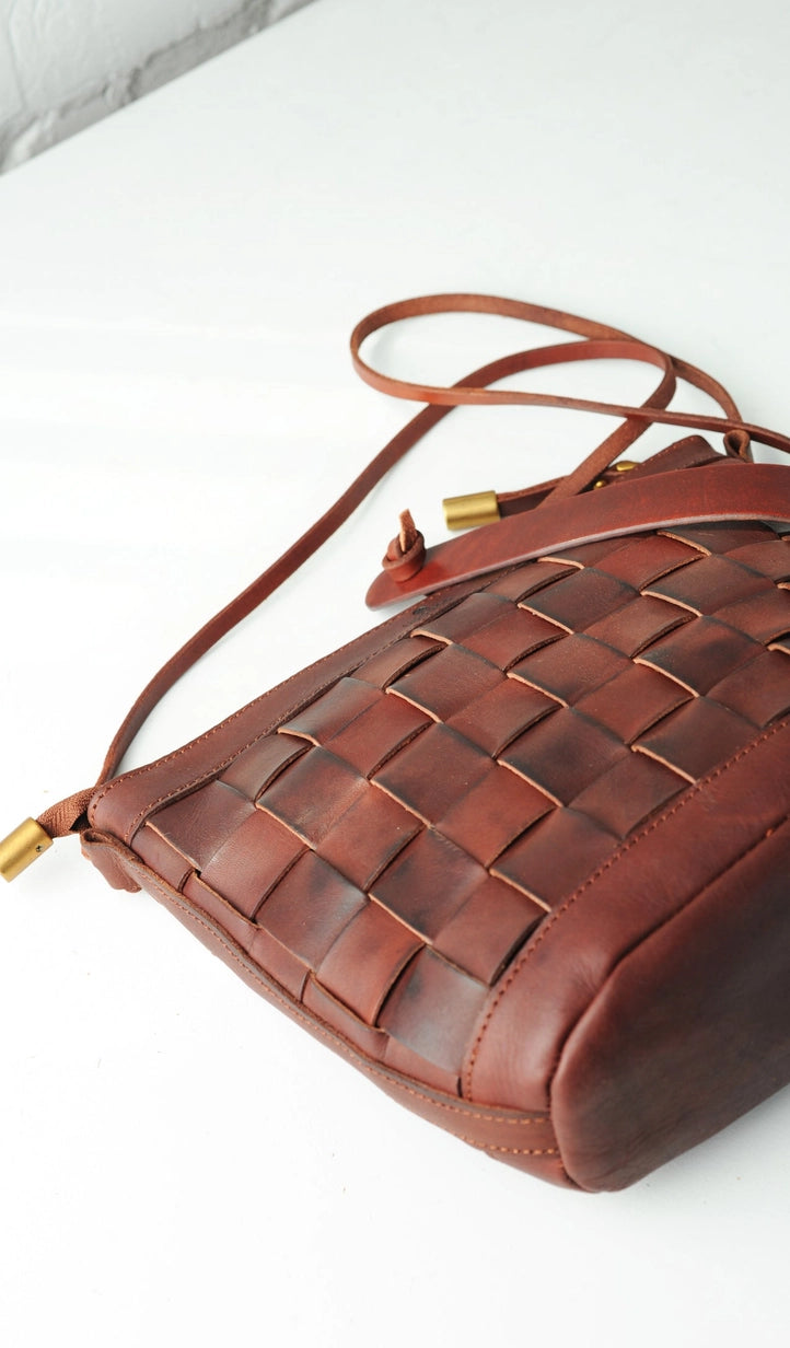 Flat lay of Chestnut Italian leather crossbody bag styled with daily accessories