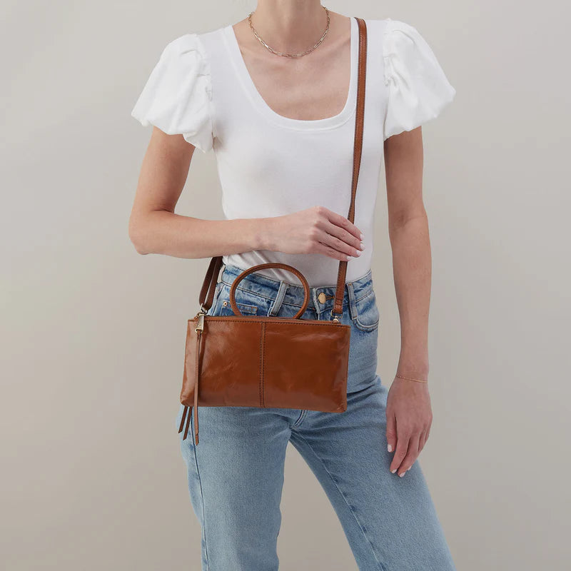 Model wearing HOBO Sable Crossbody in truffle, styled crossbody