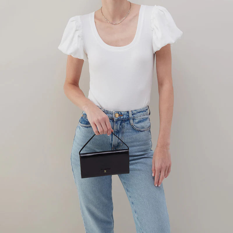 Model wearing HOBO Romy black wallet crossbody bag with adjustable leather strap