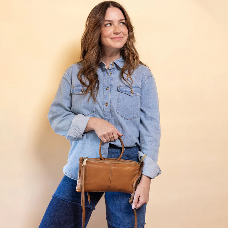 Model wearing HOBO Sable Crossbody in truffle, styled crossbody wearing casual wear.