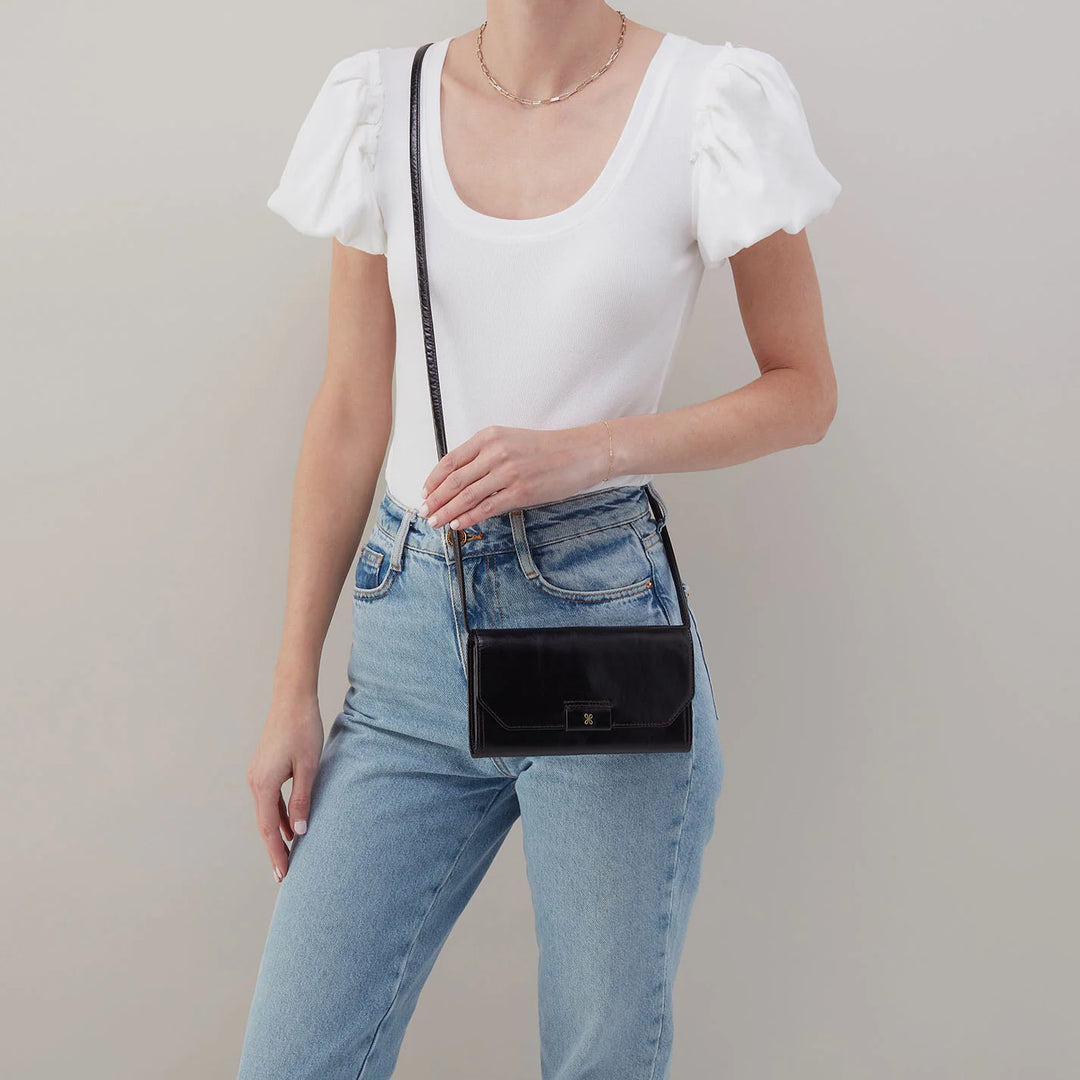 Side profile of HOBO Romy black leather wallet crossbody with strap and hardware detail