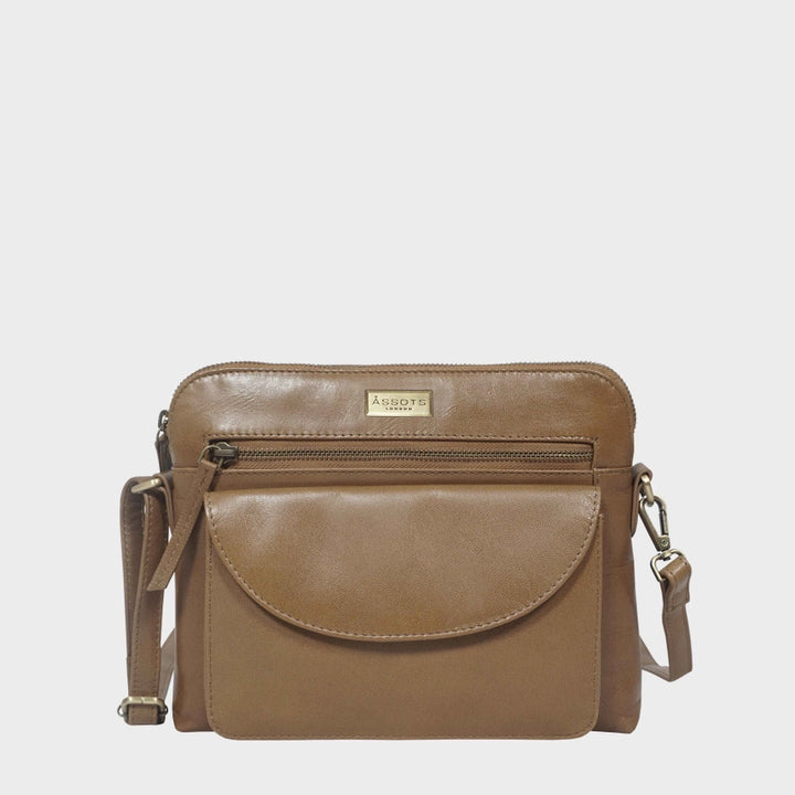 Tan vegetable-tanned genuine leather crossbody bag with zip compartment and flap closure.