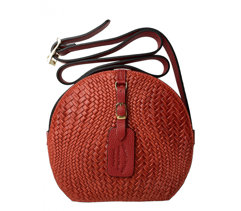 Italian round crossbody bag handcrafted in Italy with woven straw body and genuine Dollar leather strap by Fior di Loto.